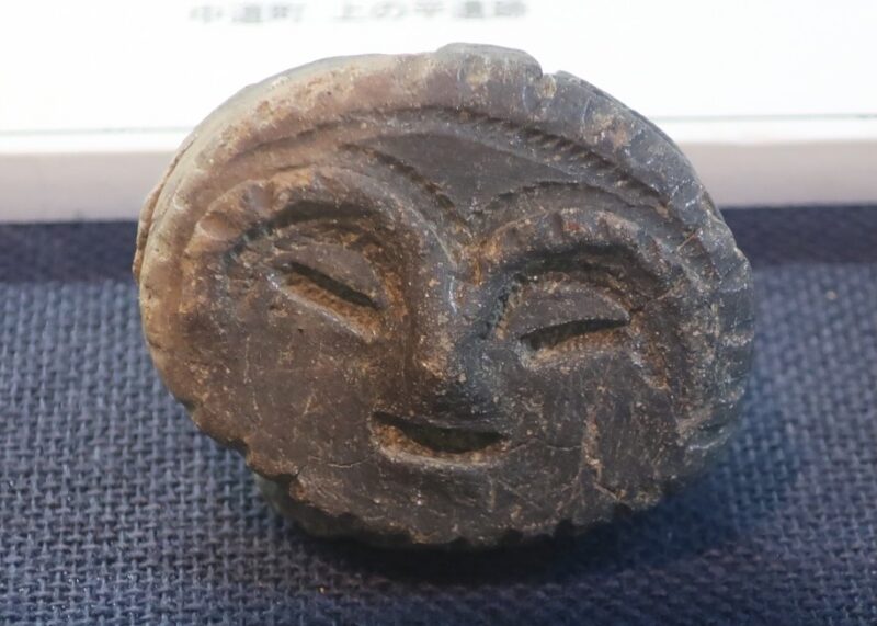 山梨県立考古博物館に展示されている黒っぽい顔だけの土偶